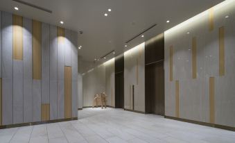 a modern office building with a long hallway and a person standing in the middle of the room at Hotel Metropolitan Akita