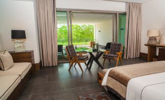 a modern living room with large windows , wooden furniture , and a view of trees outside at Nizuc Resort & Spa