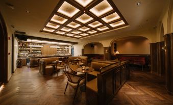 The restaurant features tables and chairs in the center, accompanied by an illuminated ceiling at Foshan Lushan Hotel (Shunde Qinghuiyuan)