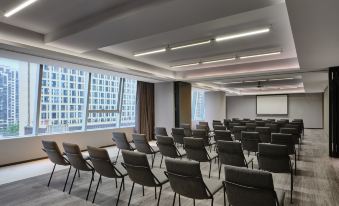 A large room with rows of chairs and a projector screen mounted in front at Wanda Moments