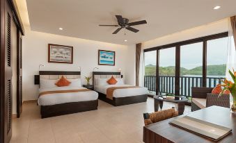 a hotel room with two beds , a couch , and a window overlooking the ocean view at Busuanga Bay Lodge