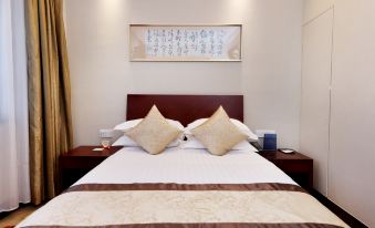 The bedroom features a spacious bed with an oriental-style headboard and hanging lights at Yan An Hotel