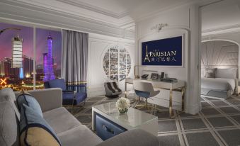 The room is furnished with large windows, chairs, and tables in the living area at The Parisian Macao