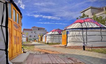 There is a grouping of tents and buildings in the background, one of which has been painted at Colorful Danxia Yimi Sunshine Inn