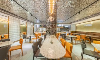 The restaurant features a central arrangement of tables and chairs, all facing an open dining area, providing a spacious and inviting setting for guests to dine at Guangzhou Atour Hotel(Zhujiang New Town Wuyangcun Subway Station)