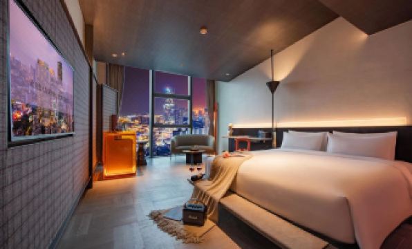 elegant and spacious bedroom with large windows and a balcony that offers a stunning view of the city at night at Grade Hotel Shenzhen sea world