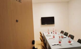 A meeting room is set up with a long table and chairs in front of the doorway at Dayin International Youth Hostel（East Nanjing Road & The Bund）