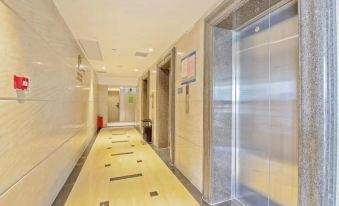 There is a long hallway with doors and an elevator in the middle, leading to another room at Hangtai Hotel (Shenzhen Science Park Window of the World)