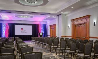 a conference room with rows of chairs arranged in a semicircle , and a large screen on the wall at Marriott Dallas Las Colinas