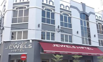 "a white building with a red awning that says "" jewels hotel "" in the front of the building" at Jewels Hotel