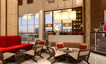 a modern hotel lobby with a large window , several chairs and couches arranged around the room at Hallmark Regency Hotel - Johor Bahru