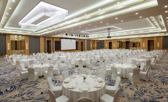 a large banquet hall with round tables covered in white tablecloths and chairs arranged for a formal event at Rixos Water World Aktau