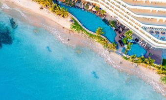 aerial view of a large resort with a pool surrounded by palm trees and a beach at Seashells Phu Quoc Hotel & Spa
