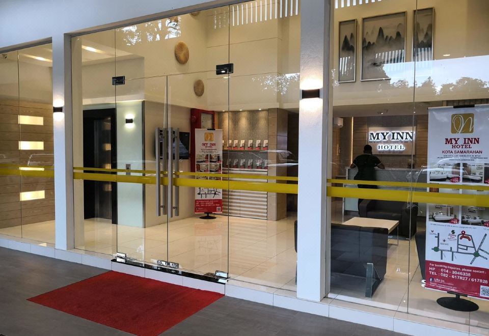 a storefront with a yellow tape on the glass door and a person standing outside at My Inn Hotel Kota Samarahan