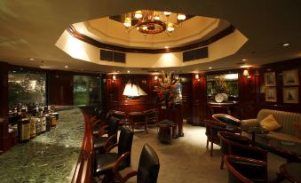 a luxurious restaurant with wooden tables and chairs , a chandelier , and a marble wall , as well as a view of the dining area at Noboribetsu Grand Hotel