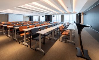 a large conference room with rows of long tables at the front and a far end at Atour Hotel Shunde Happy Coast Foshan