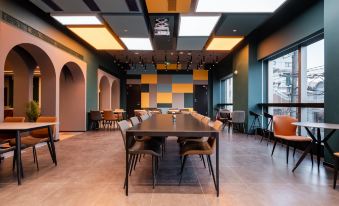 There is a large room with long tables and chairs, and an office space is located along the far wall at Dayin International Youth Hostel（East Nanjing Road & The Bund）