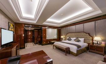 The middle room features a spacious bed, along with a sitting area and table attached to one side at Fuzhou Oriental Yanzhuo Hotel