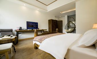 The middle room features a large bed and an open concept that connects to the living area and sitting space at Hotel Blanche Yading