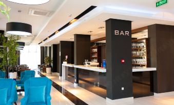 a modern bar with black and white color scheme , including a counter , stools , and a bar area at Bosphorus Hotel