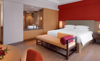 a modern hotel room with a large bed , a bathroom with a bathtub , and a dining area at Hyatt Regency Kuantan Resort