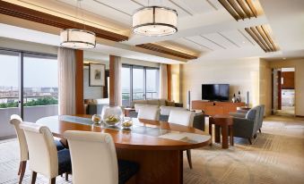 a dining room with a round dining table surrounded by chairs , and a television in the background at Sheraton Grande Tokyo Bay Hotel