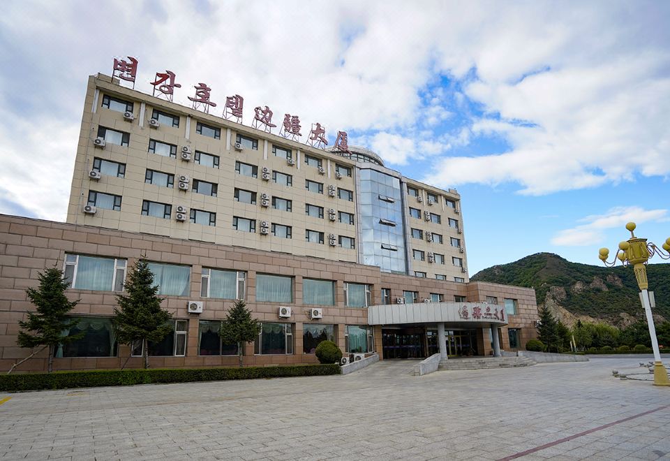 a large hotel building with multiple entrances and a parking lot in front of it at Frontier Building