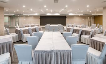 A spacious conference room is prepared with tables and chairs, ready for use at Guangzhou Tianhe Taikoohui - Coffee Rupin Hotel