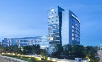 "There is a large building with the word ""hotel"" on the front and another building behind it" at Grand Barony Qingdao Airport Hotel