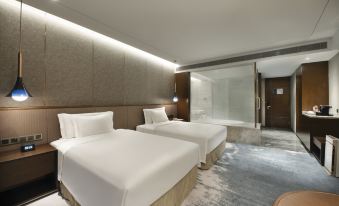 A contemporary bedroom featuring double beds and a spacious sitting area in the center at Grand Barony Qingdao Airport Hotel
