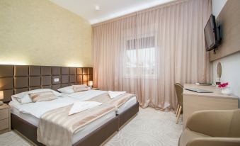 a hotel room with two beds , one on the left and one on the right side of the room at Royal Airport Hotel