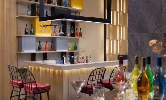 The open concept kitchen is located along the wall, with a bar featuring chairs and tables in front at Yishang Hotel (Guangzhou Beijing Road Pedestrian Street Tianzi Wharf)