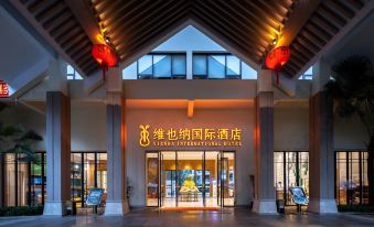 "The entrance to a hotel features large windows and an illuminated sign that says ""welcome"" above it" at Vienna International Hotel (Baoting Center)