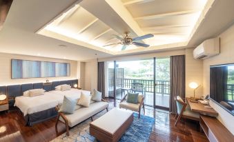 a modern hotel room with wooden floors , white furniture , and a balcony offering views of the ocean at Okuma Private Beach & Resort
