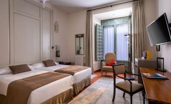 a hotel room with two beds , one on the left side of the room and the other on the right side at Parador de La Granja