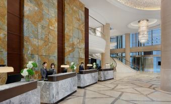 The hotel lobby features elegant marble and wood accents on both sides at Shanghai Marriott Marquis City Centre