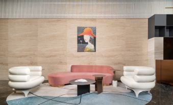 There is an abstract painting on the wall next to the couch in a room that also has two chairs and tables at Citadines Apart Hotel (Shanghai Yan'an West Road)