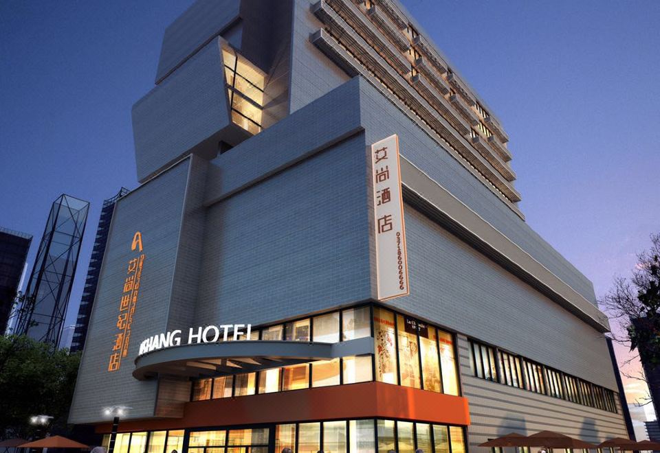 The exterior view at night showcases a large building in front and an office block at Aishan Hotel (Foshan Shunde Lecong Furniture City store)