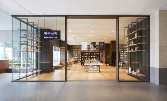 a modern bookstore with large glass doors and shelves filled with books , creating an inviting atmosphere at Lahan Hotel Jeonju