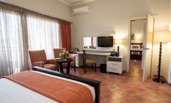 a modern hotel room with a bed , desk , and tv , along with various amenities such as chairs and a desk at Haile Resort Hawassa