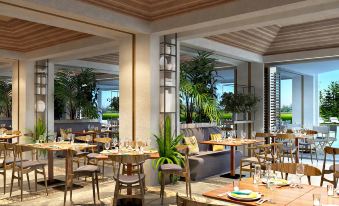 a restaurant with wooden tables and chairs , a couch , and potted plants on the walls at DoubleTree Resort by Hilton Hotel Penang