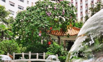 There is a fountain in the center with buildings in the background, and water is cascading down from the buildings at China Hotel