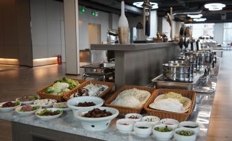 There is a table in the middle with food on it, and there are also bowls next to it at Shenzhen Hyde Hotel