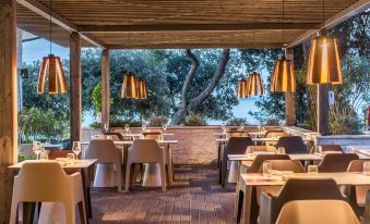 an outdoor dining area at a restaurant , with several tables and chairs arranged for guests to enjoy their meal at Hotel Pinija