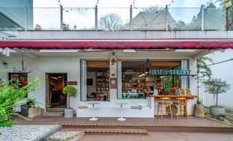 There is an outdoor seating area with tables and chairs located outside the front door of the restaurant at Little Forest Guesthouse