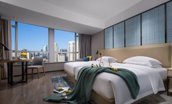 The bedroom features large windows, a centrally positioned bed, an elevated bedside table with a lamp, and a spacious wardrobe for storage at Echarm Hotel (Guangzhou Beijing Road Pedestrian Street Tianzi Pier)