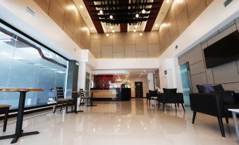 The lobby features chairs and tables arranged in the center, adjacent to an open floor plan at Hotel Sogo Fairview