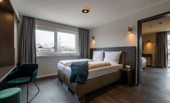 a hotel room with two beds , one on the left side of the room and the other on the right side at Maseven München Messe Dornach