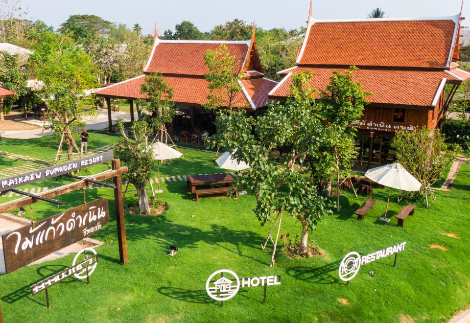 aerial view of a resort surrounded by trees , with several chairs and umbrellas placed around the property at Maikaew Damnoen Resort