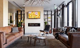 a modern living room with a large flat - screen tv mounted on the wall , surrounded by comfortable couches and chairs at Quest Bendigo Central